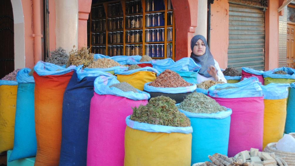 Market vendor with bins of herbs at a market in Marrakech