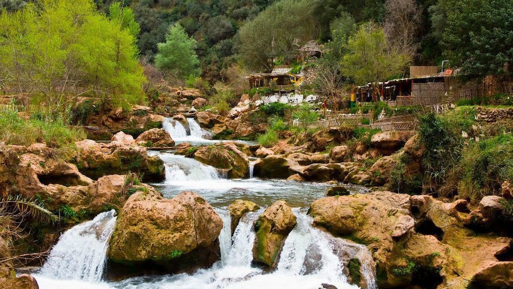 Succession of pools and small waterfalls with huts along the bank of the river in Ourika Valley