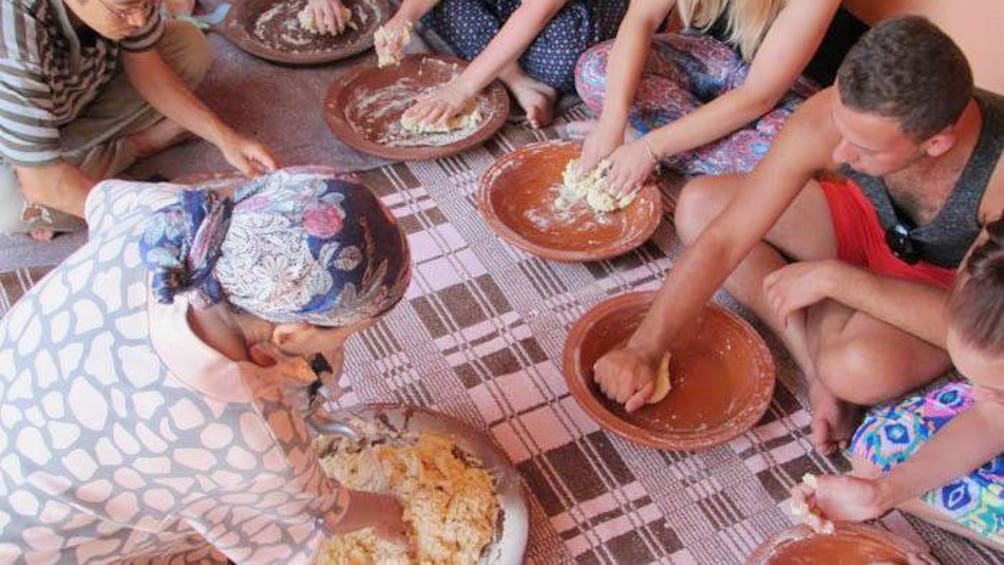 Seated group kneading dough by hand in a Berber village near Marrakech
