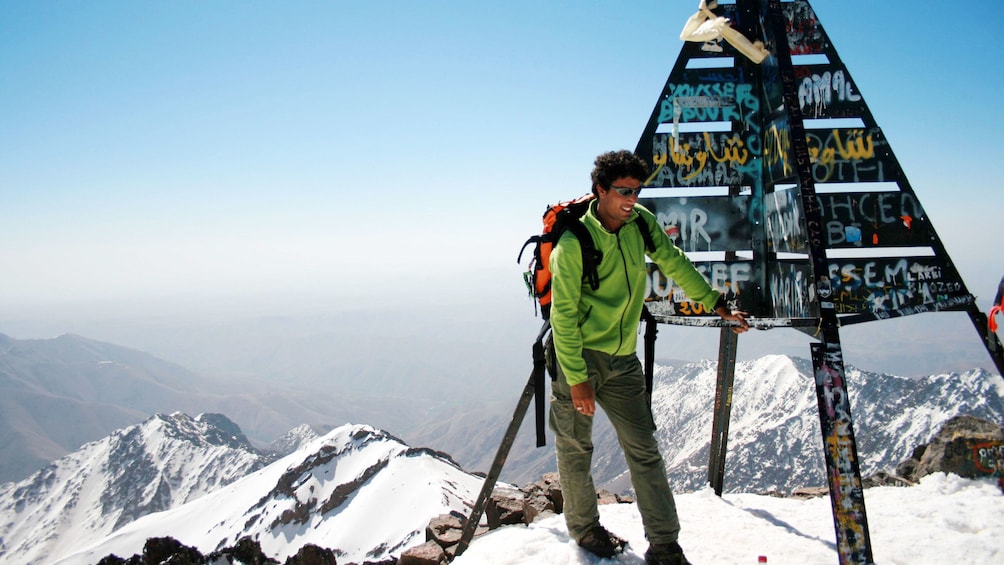 Man standing on top of the snow-capped Atlas Mountains in Marrakech