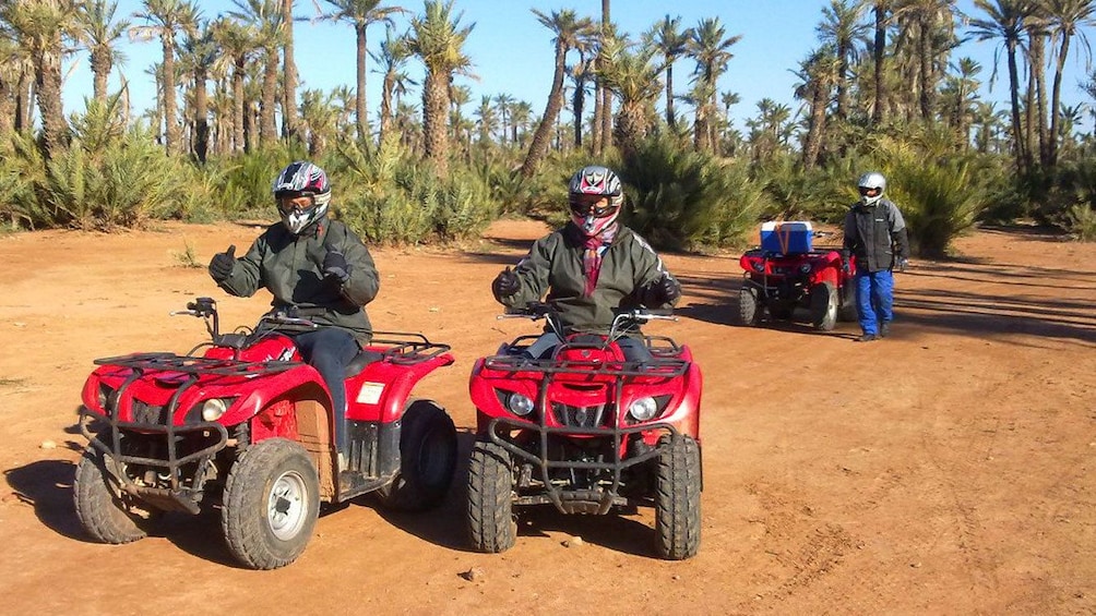 Quad-biking group with palm groves in the background in Marrakech