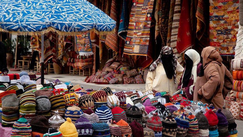 Woven hats and rugs for sale at a market in Marrakech