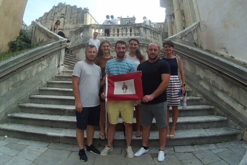 Group photo with the historic flag of Dubrovnik Republic at the Jesuit steps