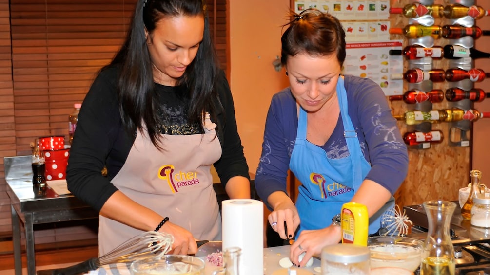 Two young ladies preparing to make a meal at the Hungarian Cooking Class in Budapest 
