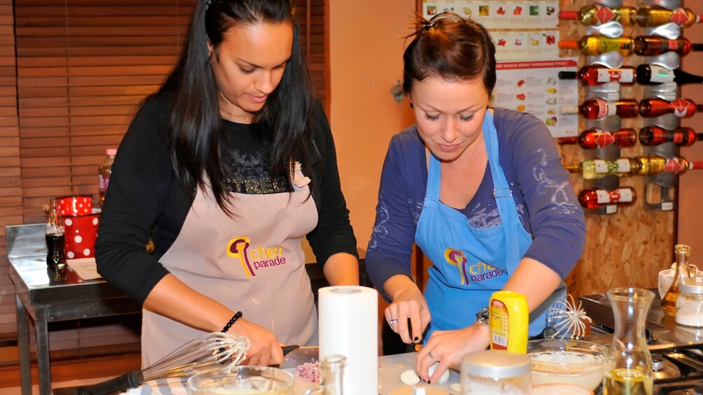 Two young ladies preparing to make a meal at the Hungarian Cooking Class in Budapest