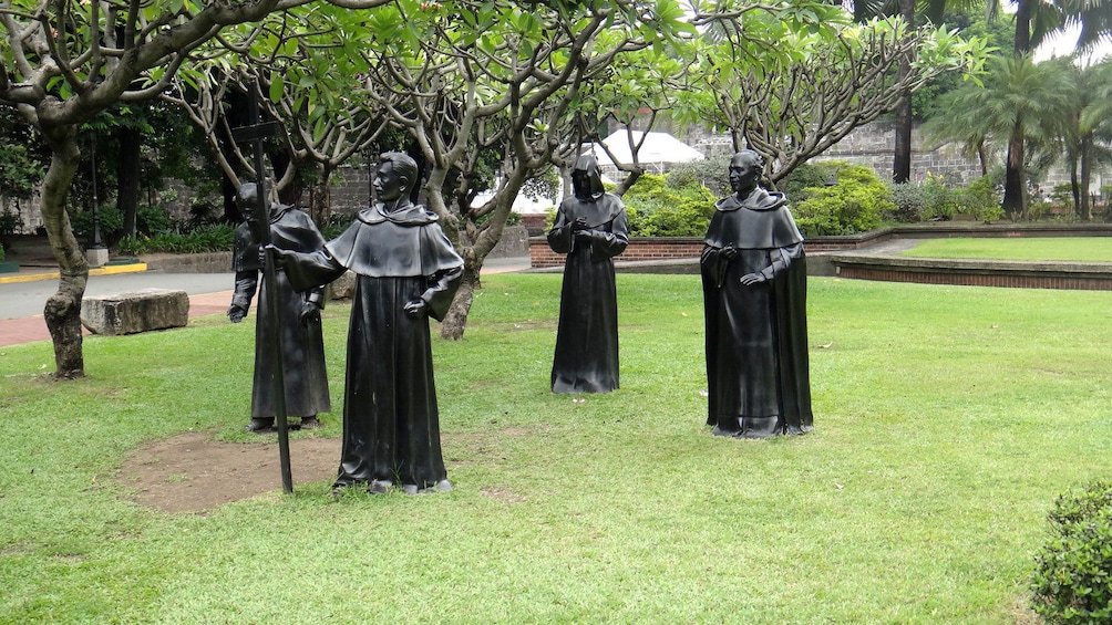 Statues of robes priests in a park in Manila