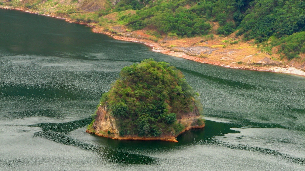 Tree covered rock island in Taal Lake in Tagaytay