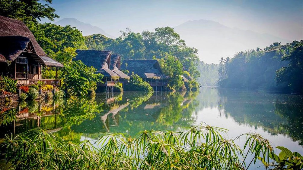 Stilt houses line the edge of Labasin Lake at Villa Escudero Plantations in San Pablo City, Philippines