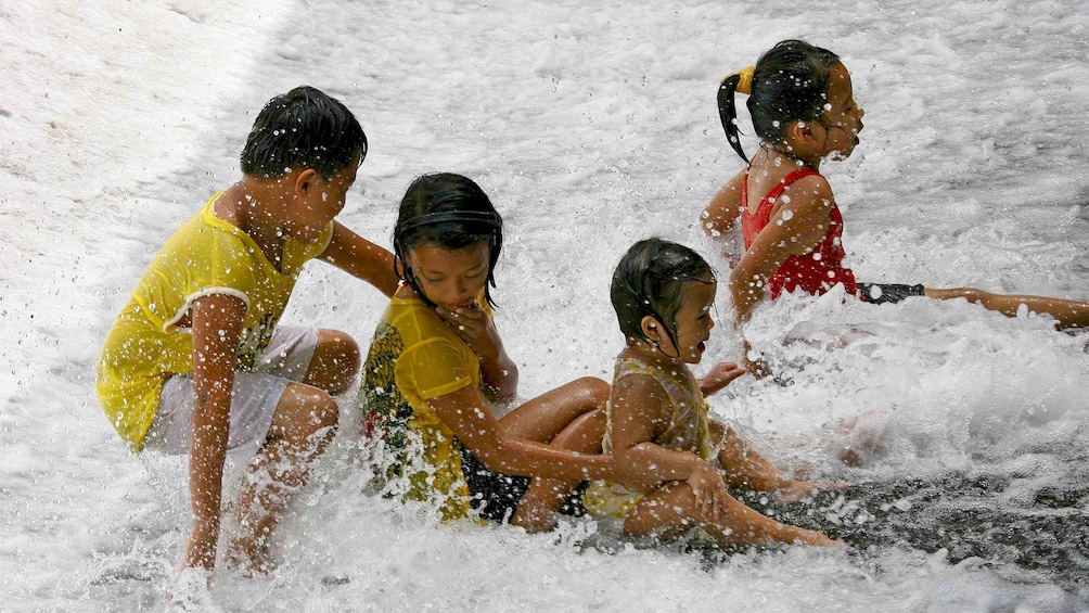 Group of children playing in the water at Villa Escudero Plantations in San Pablo City, Philippines