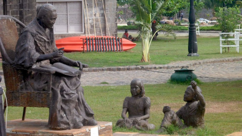 Statue of an old woman reading to children at Las Casas Filipinas Resort in Manila