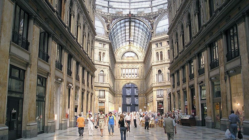 Charger l’élément 1 sur 5. People walking through a shopping center with a high glass ceiling in Naples