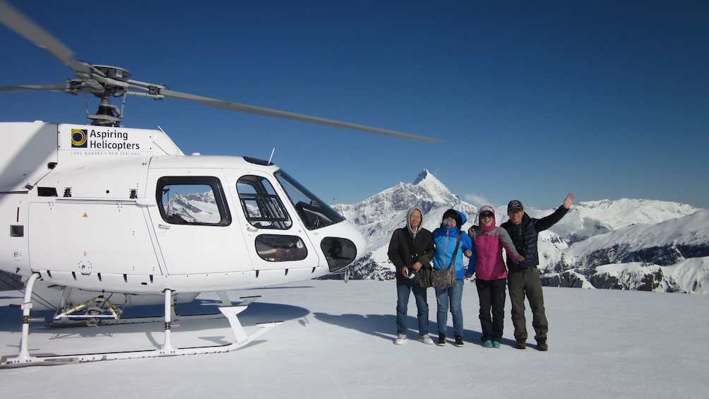 Tour group next to a Helicopter on a mountain top