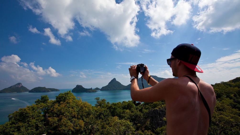 Man taking picture of mountains and water in Koh Samui