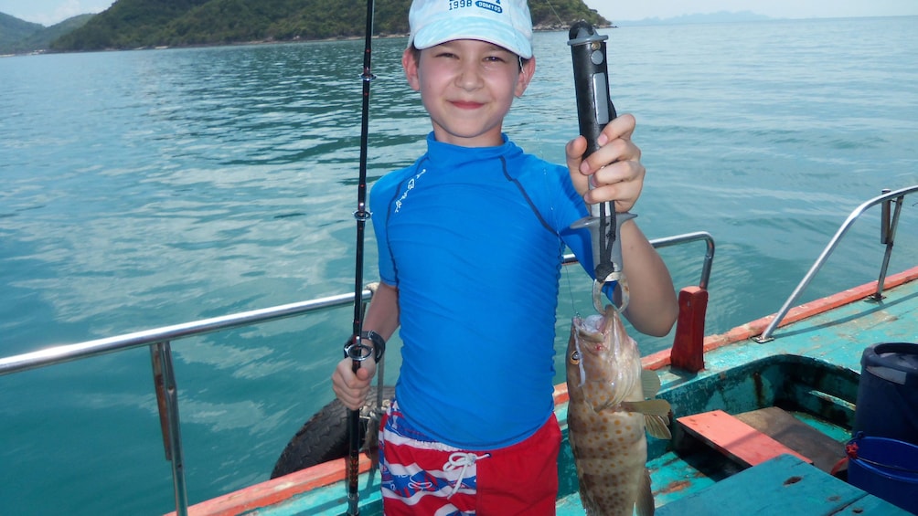 Boy holding fish in Koh Samui