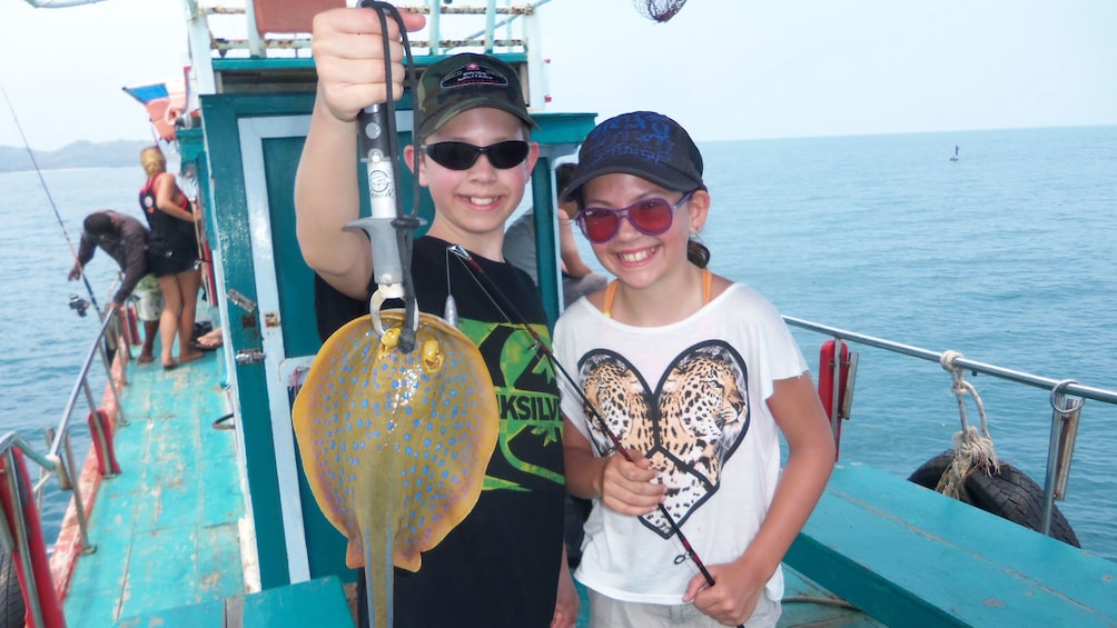 Kids holding up a fish in Koh Samui