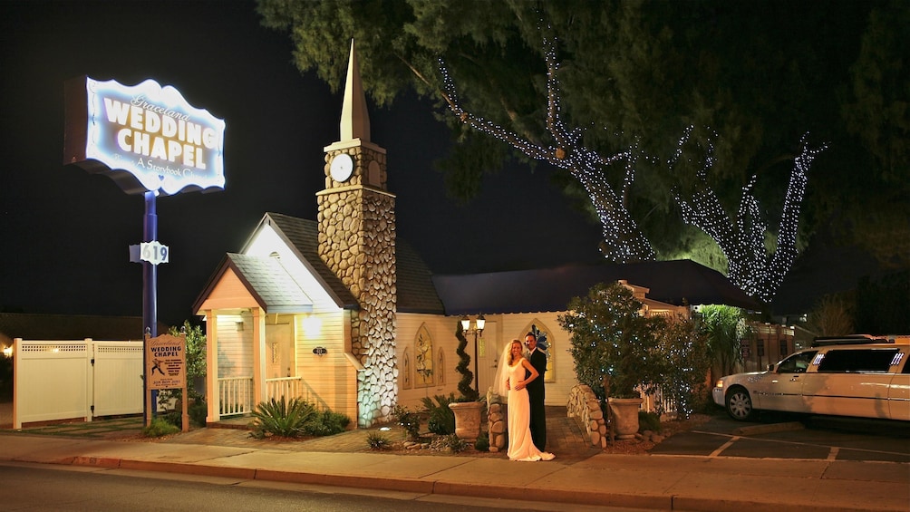 Evening photo with a happy bride and groom in front of the storybook wedding chapel