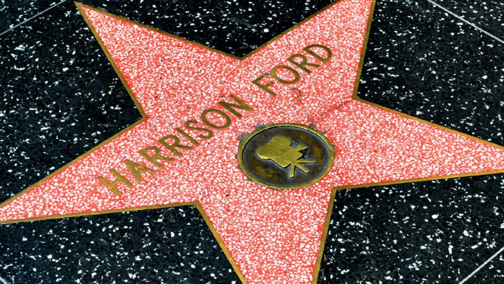 Walk down the Hollywood Walk of Fame to see star plaques of famous movie actors like Harrison Ford