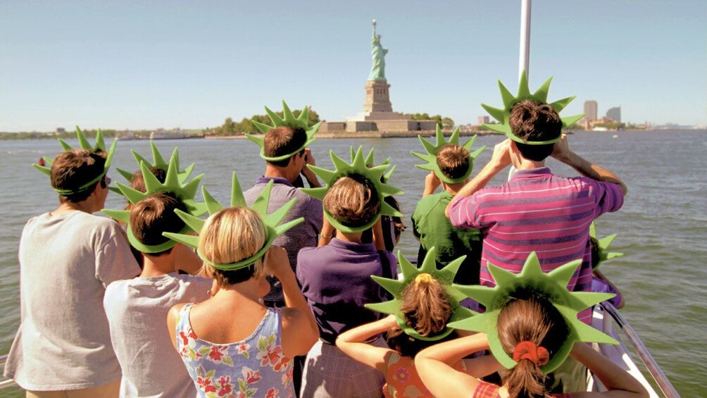 Tour group on a boat looking at the Statue of Liberty in New York