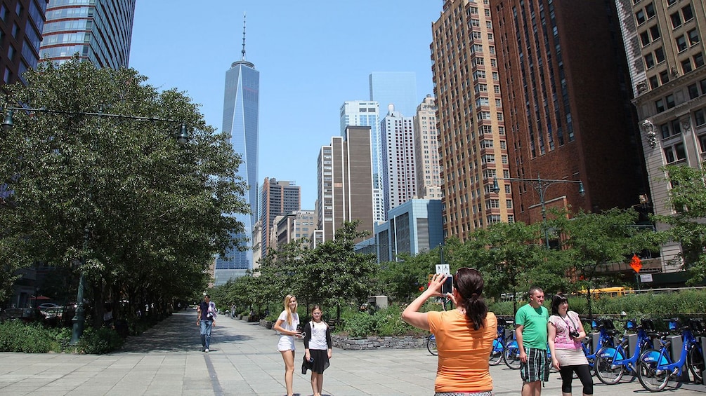 Woman taking photo of girls with Freedom Tower in background