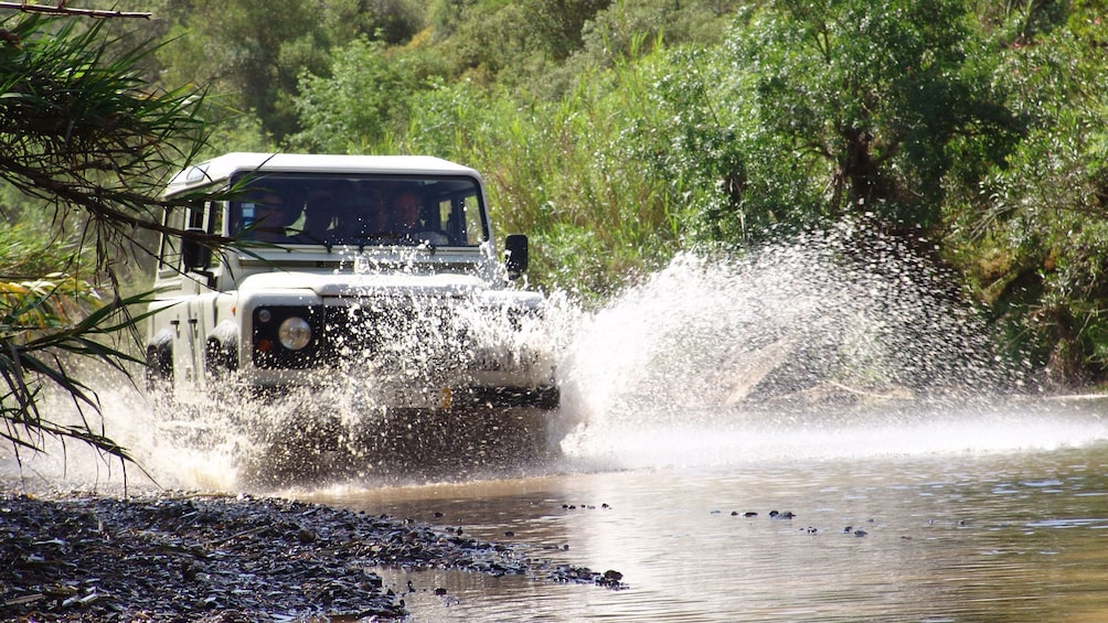 Jeep splashing through the water in Algarve