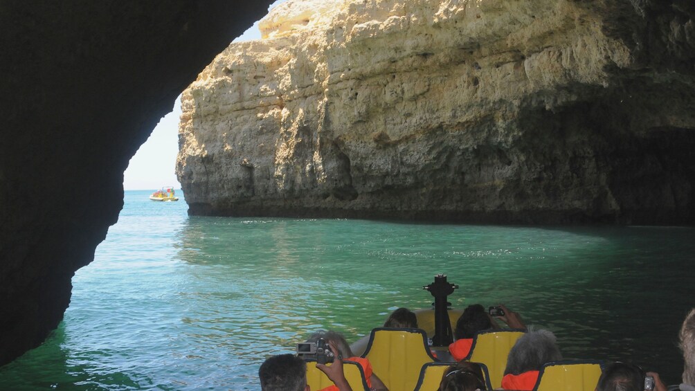 Boat traveling under the rock arches of the Insonia Caves in Algarve