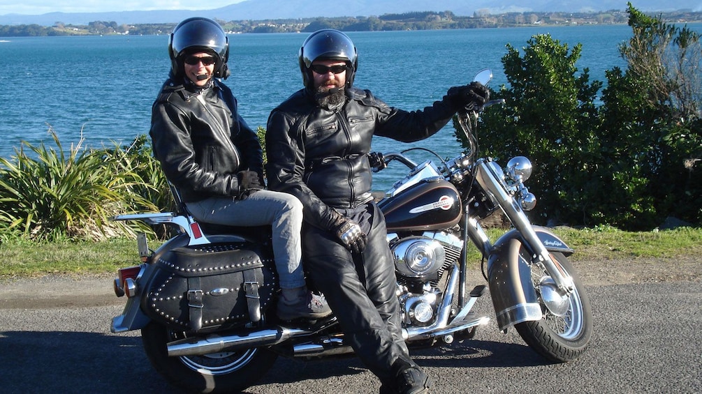 Harley rider and passenger parked along the coast in Auckland