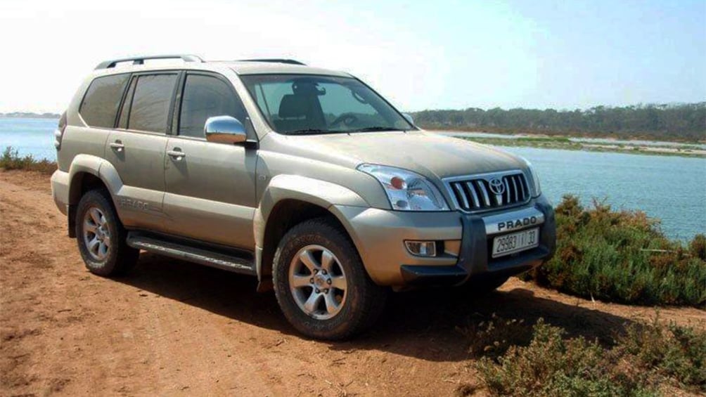 SUV on a dirt road along a river near Assaka