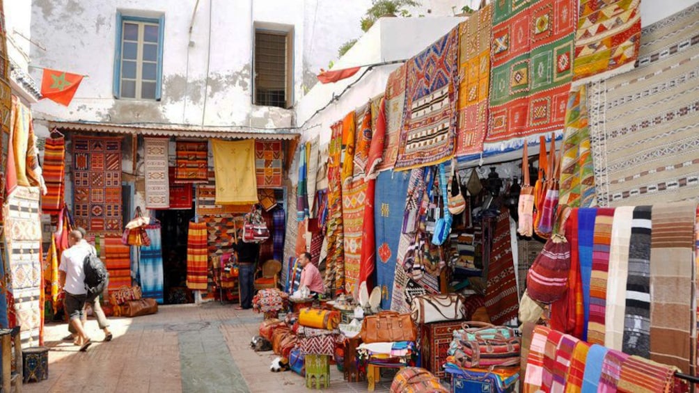 Colorful rugs and handmade goods for sale at a market in Essaouira