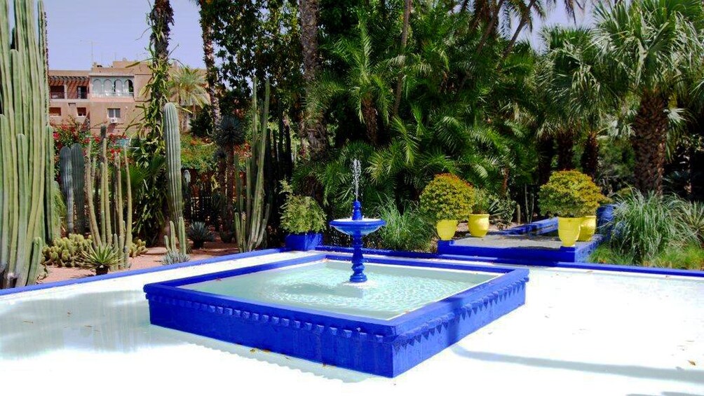 Blue fountain with surrounding gardens in Marrakech