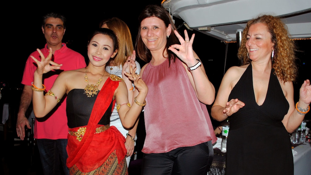 People with a performer on a dinner cruise in bangkok