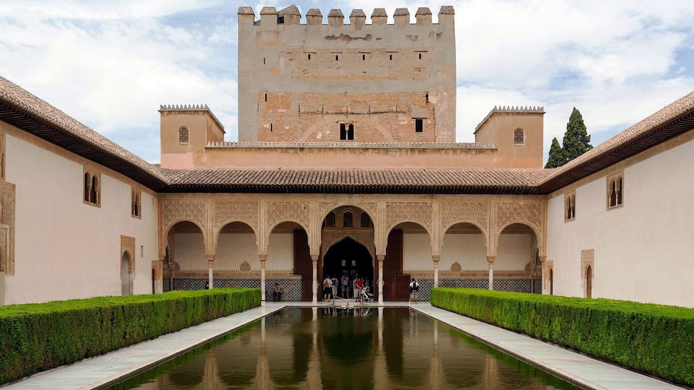 visitors near a small pond at the Alhambra palace in Granada