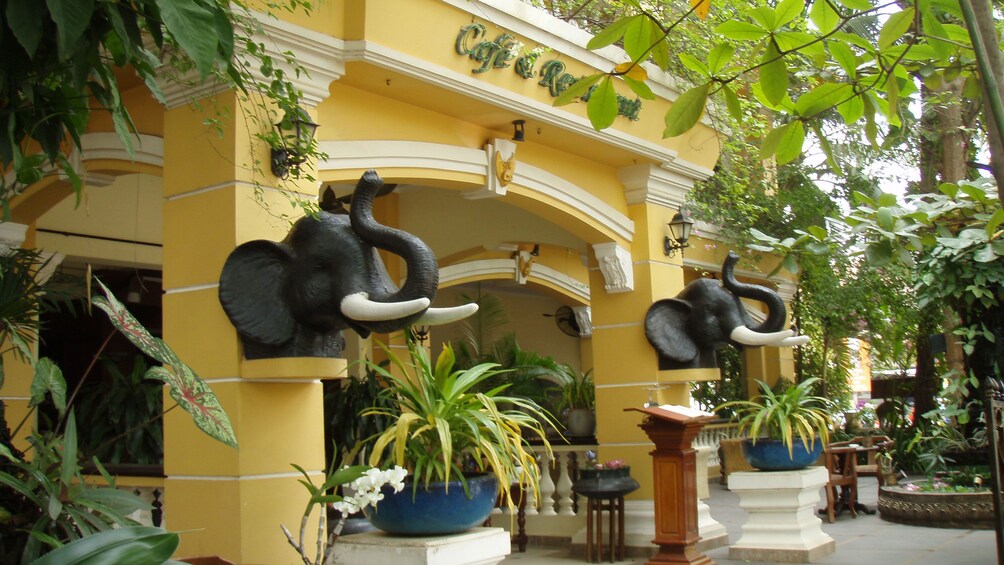 Two elephant figurines in front of a yellow building in Siem Reap 