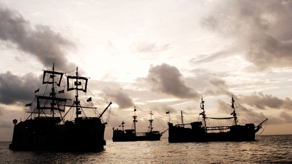 Charger l’élément 4 sur 8. Pirate ships silhouetted at sunset