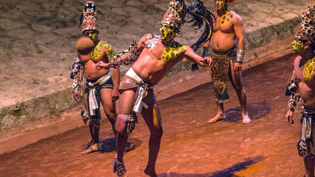 Man in native dress playing futbol