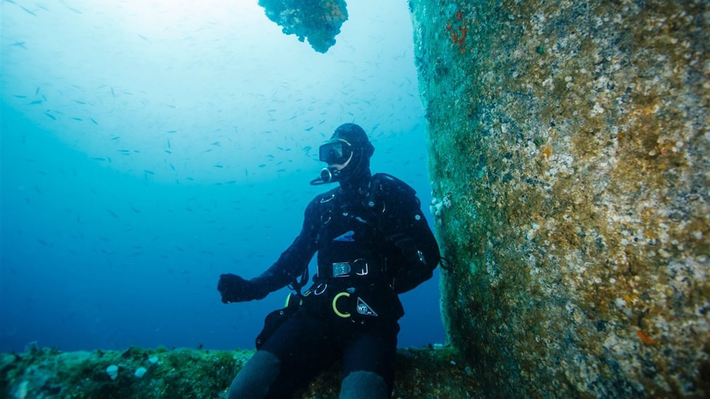 Scuba diver sitting on a sunken structure in Cancun