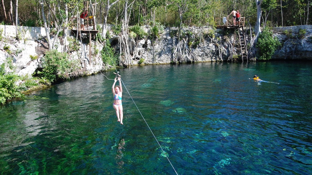 Zip lining into a cenote in Cancun