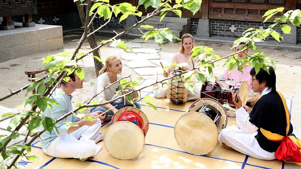 Show item 5 of 5. Tourists learning about Korean musical instruments at the Korea House in Seoul