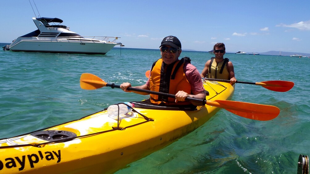 Two sea kayakers near a boat at Mornington Peninsula