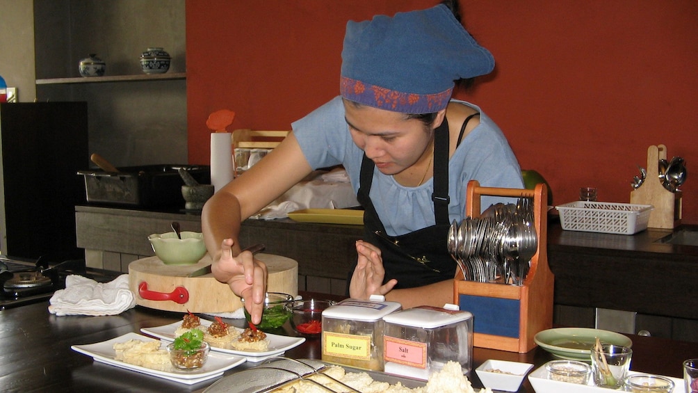 Woman plating a dish of food in Chiang Mai