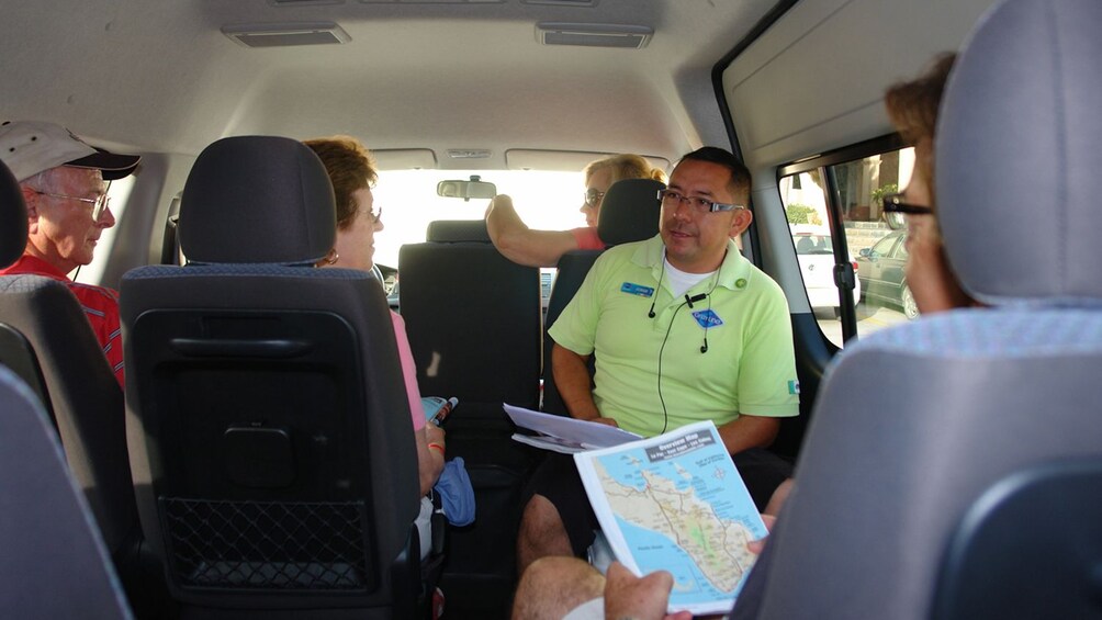 tour guide sitting with passengers in van in Los Cabos