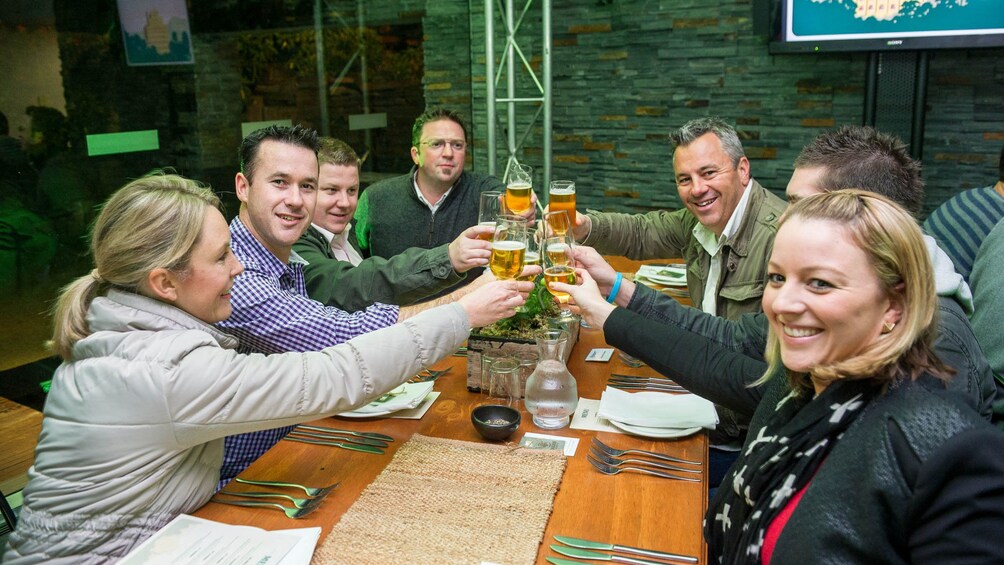 Table of guests holding beers at the Cascade Brewery Heritage Tour in Tasmania Australia 