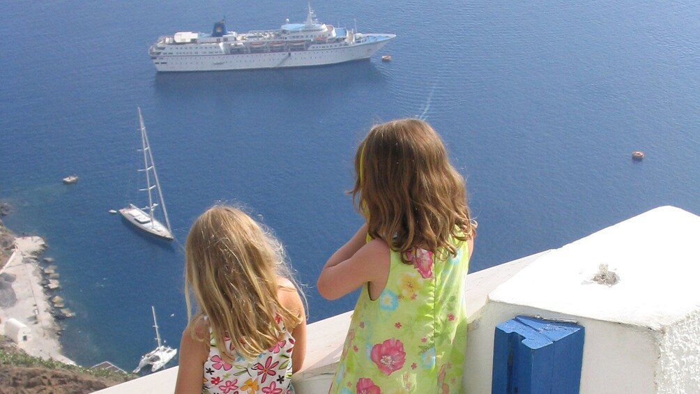 Children watching boats below in Santorini