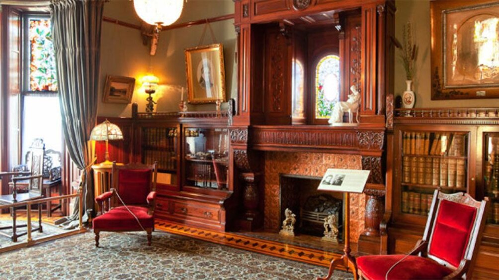 Velvet chairs on either side of a fireplace in one of the rooms of Craigdarroch Castle in Victoria