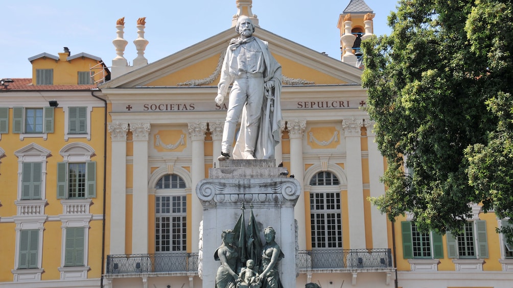 statue in front of yellow house in france