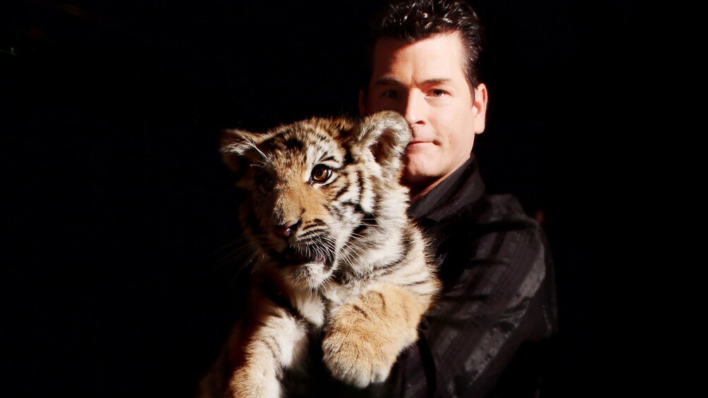 Magician Greg Frewing holding a tiger cub in Niagara Falls
