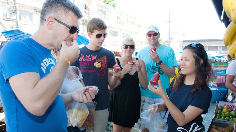 cooking students tasting ingredients at the market in Phuket