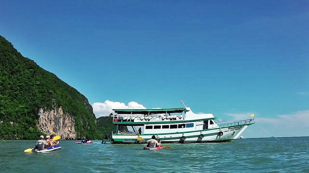 kayakimg near a boat in Phuket