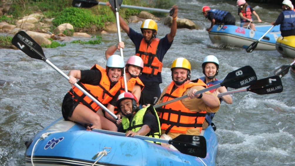 whitewater rafters posing with paddles in Phuket