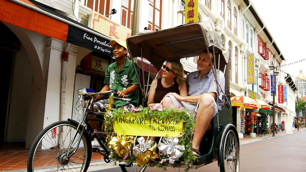 people in tricycle carriage touring chinatown in Sinapore