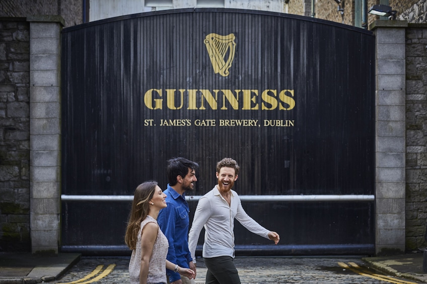 Friends walk in front of the Guinness Brewery